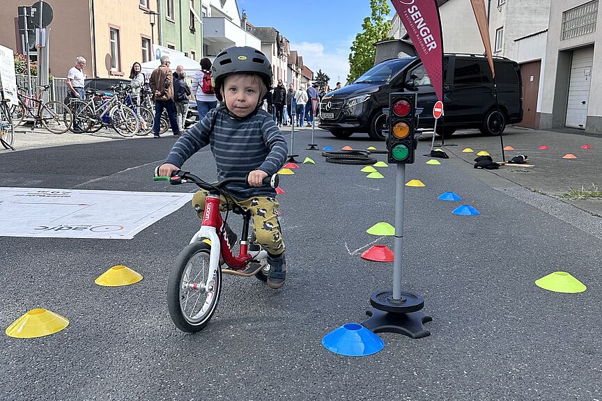 Fahrradparcours 2026 kleiner Junge mit Laufrad zwischen Hütchen unterwegs