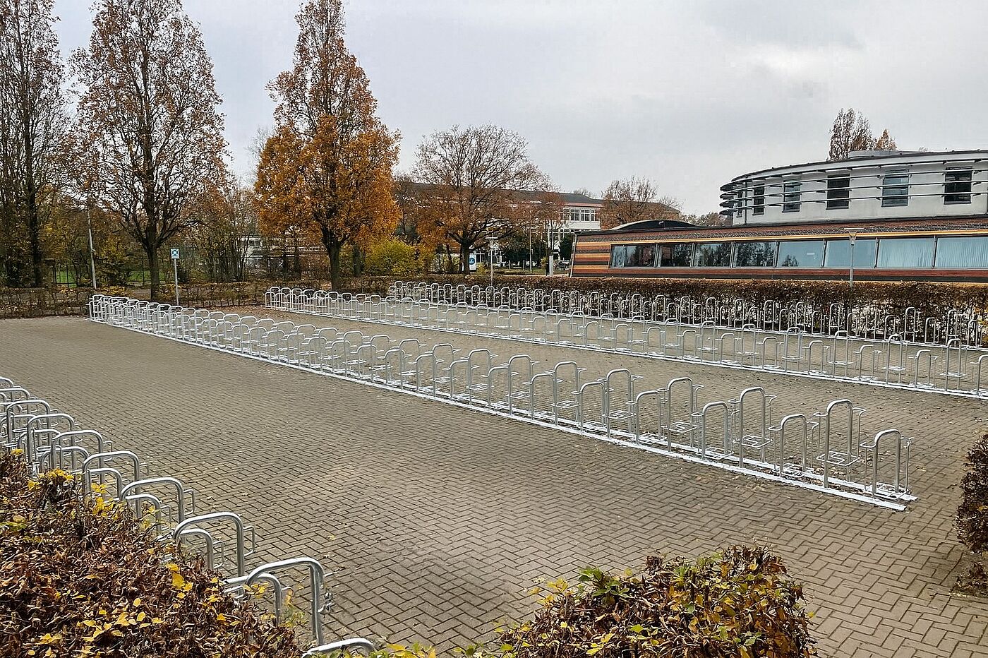 Radpa Alex Eine Fahrradabstellanlage aus Stahl auf einem Parkplatz.